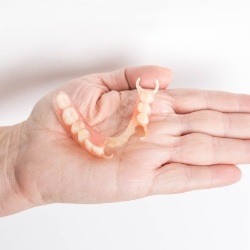 Hand holding a partial denture
