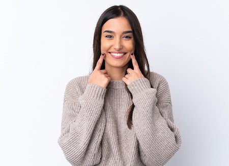 Smiling woman holding Invisalign tray
