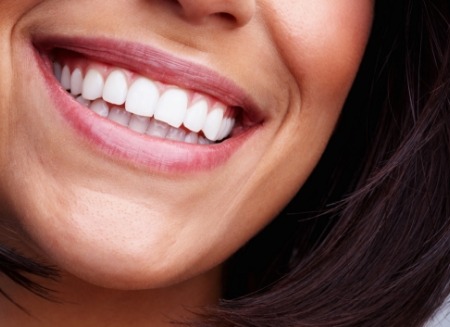 Close up of person smiling with straight white teeth