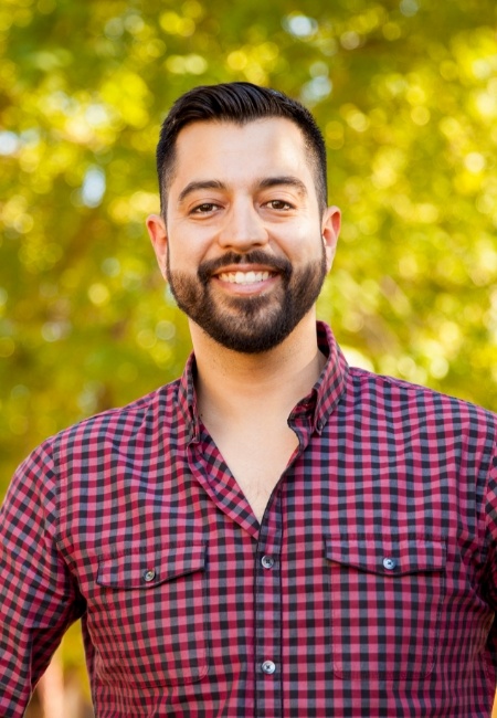 Man in red plaid shirt smiling with dental crowns in Sachse