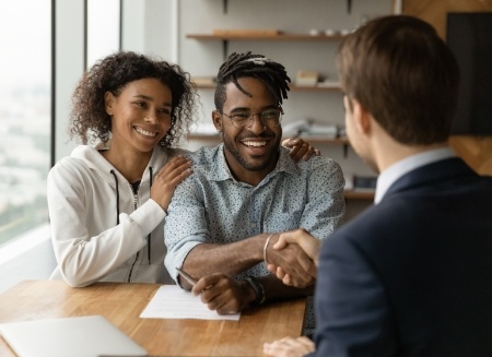 Man shaking hands with man across desk