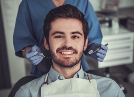 Young man with short beard in dental chair