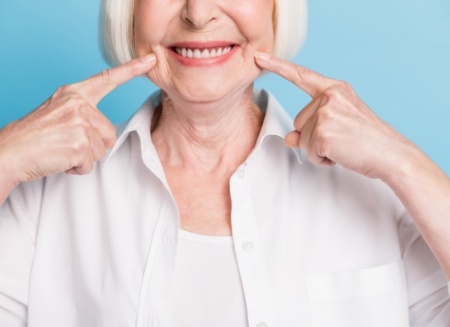 Senior woman pointing to her smile