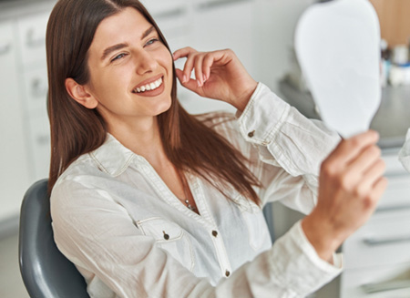 Woman smiling while looking at reflection in mirror