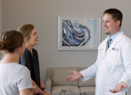 Doctor Rottman smiling at two dental patients