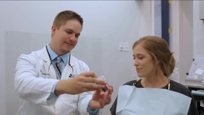 Sachse dentist showing a model of the mouth to a patient