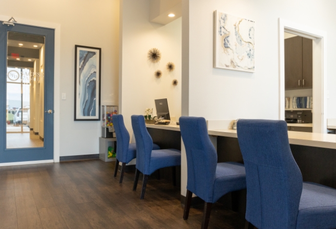 Row of blue chairs at front desk of Sachse Family Dentistry at Woodbridge