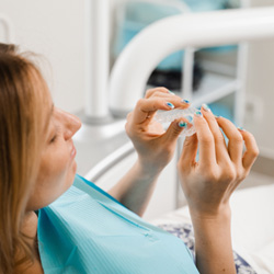 Patient holding clear aligner in treatment chair
