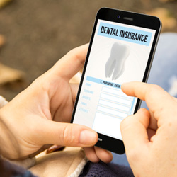 Patient looking at dental insurance form on phone outside