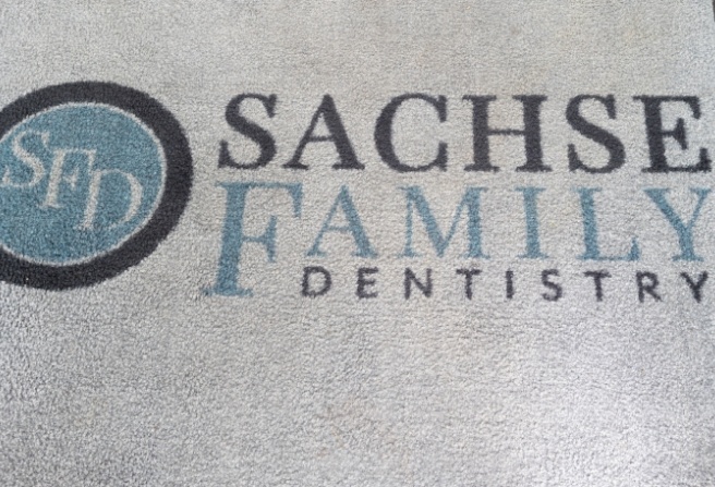 Close up of rug with Sachse Family Dentistry at Woodbridge logo