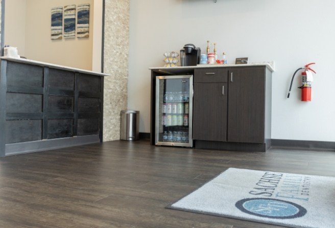 Sachse Family Dentistry at Woodbridge logo on rug in waiting room