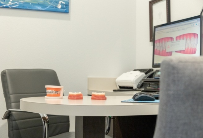 Three models of dentures on consultation desk