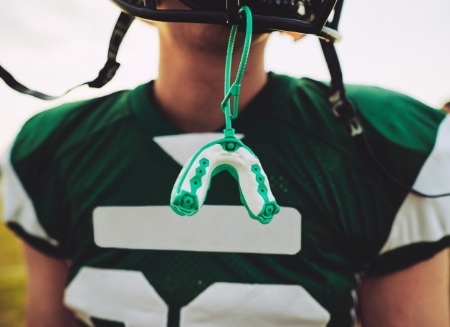 Athletic mouthguard hanging from football helmet