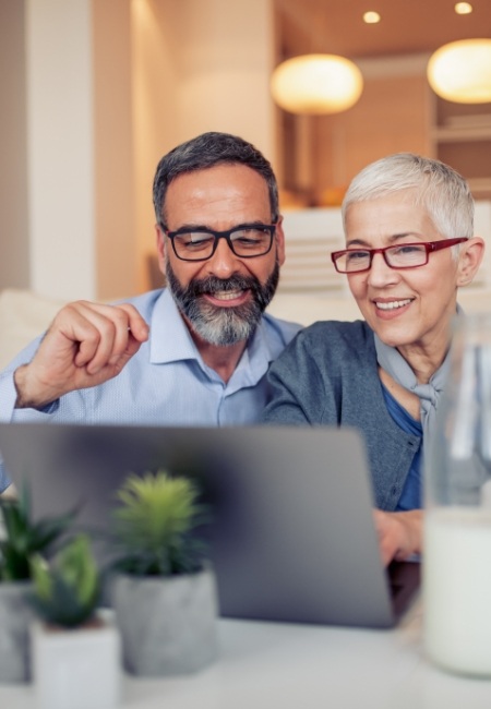 Man and woman looking up Sachse dental office on laptop