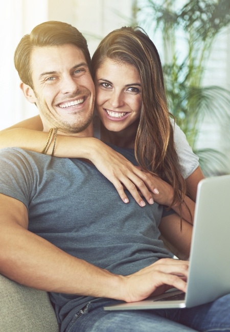 Smiling man and woman sitting on couch