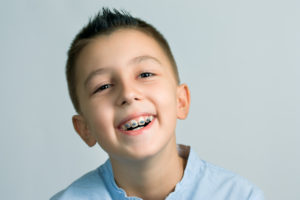young boy smiling wearing braces