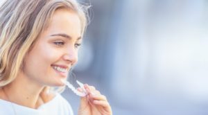 woman inserting Invisalign in Sachse