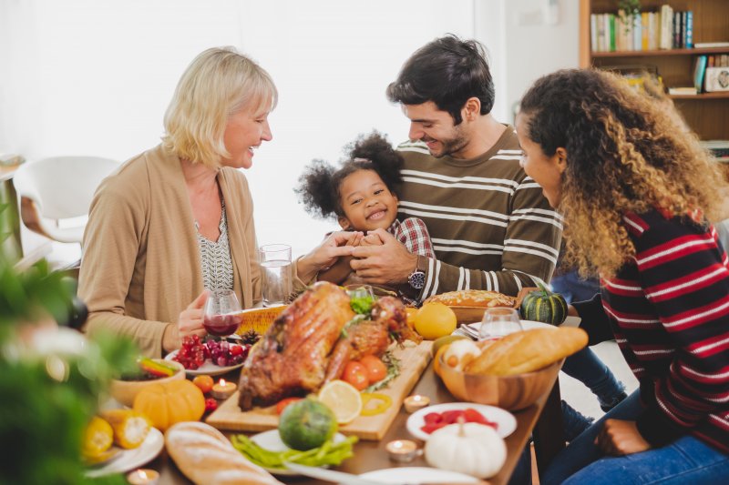 family enjoying Thanksgiving dinner with dentures in Sachse