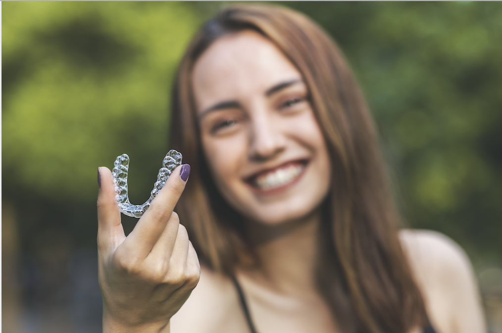 woman holding Invisalign braces   