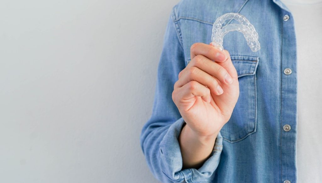 Patient holding both of their Invisalign aligners.