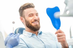 a man happily smiling at the dentist after choosing a cosmetic dental treatment