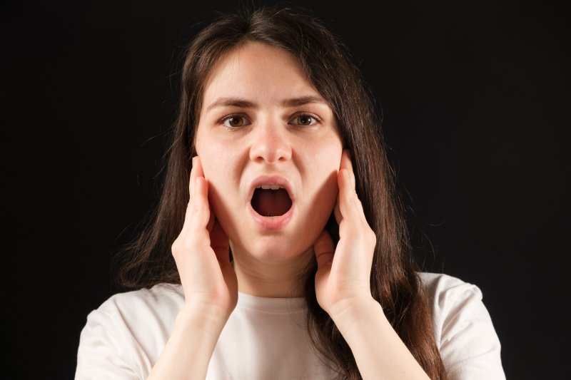 Patient holding her jaw uncomfortably