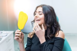 Female patient looking in dental mirror