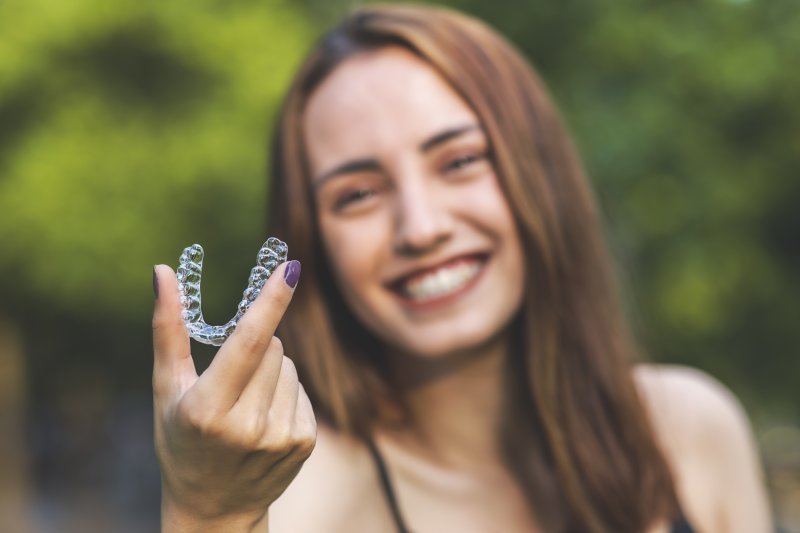 person holding retainer and smiling