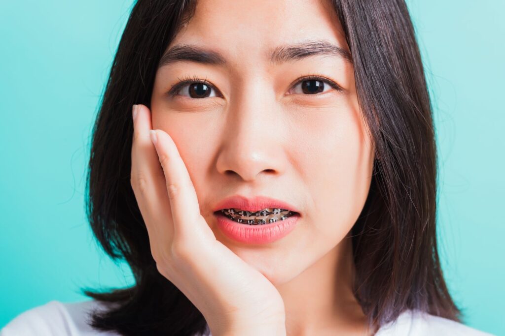 A woman with sore teeth from braces