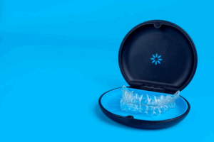 Invisalign trays sitting in their case on a blue background