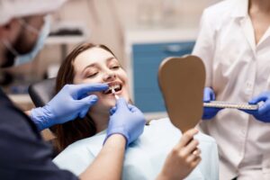 Dentist preparing to place veneer on patient's tooth.