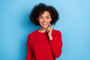Woman in red sweater happy with her whiter teeth